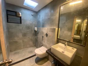 PānchuriaにあるFirangipani Suites - A Corporate Boutique Hotelのバスルーム(トイレ、洗面台、シャワー付)