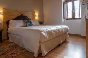 1 dormitorio con 1 cama grande y cabecero de madera en O Viso Ecovillage - Hotel Ecologico Vegano, en Orol