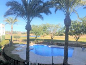 a pool with palm trees in a park at Casa Ricardo - A Murcia Holiday Rentals Property in Roldán