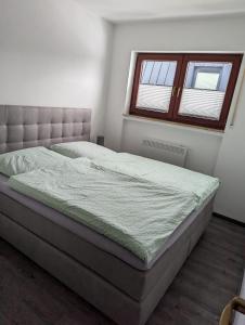 ein Schlafzimmer mit einem großen Bett in einem Zimmer mit einem Fenster in der Unterkunft Ferienwohnung Mause in Winterberg