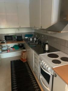 cocina con fogones blancos y fregadero en Very Nice Apartment 15 minutes from Stockholm, en Trångsund