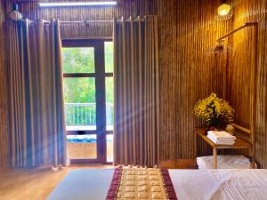 een slaapkamer met een bed en een groot raam bij Mom's homestay in Ninh Binh