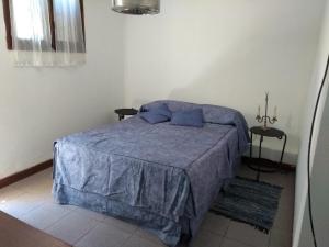 1 dormitorio con 1 cama con manta azul en Casa de Alex. en Luján de Cuyo