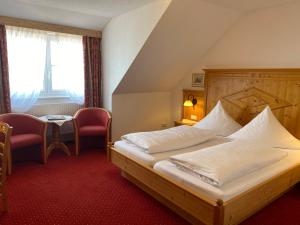 a bedroom with a large bed with a wooden headboard at Seehotel Schäpfle in Überlingen