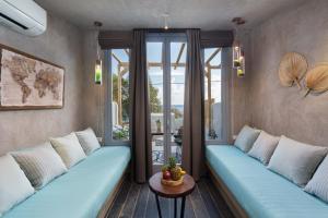 a living room with two blue couches and a table at Elixir Del Mar on the Beach in Kamari