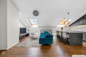 a living room with a blue couch and a table at Cozy Old Town apartment in Kaunas