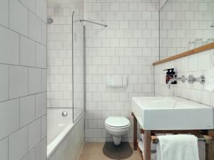 a white bathroom with a toilet and a sink at Townhouse Design Hotel & Spa in Maastricht