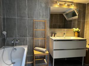 uma casa de banho com um lavatório, uma banheira e um espelho. em Villa Cocooning proche Cannes em Vallauris