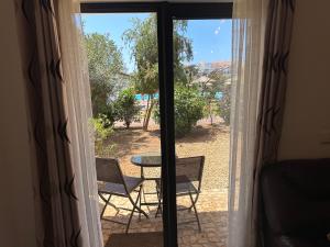 Habitación con ventana con mesa y sillas en Quality Melia Dunas Beach Resort Apt Spa Gym 7 Pools, en Santa Maria