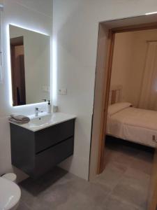 a bathroom with a sink and a mirror and a bed at Casa rural Fuente Americana in Moratalla