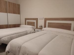 a room with three beds with white sheets at Casa rural Fuente Americana in Moratalla