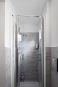 a bathroom with a shower with a glass door at Trastevere Heart Home in Rome