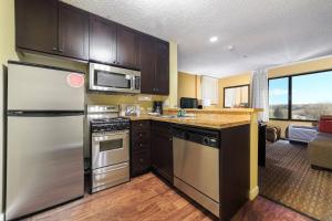 a kitchen with a stainless steel refrigerator and a microwave at TownePlace Suites Farmington in Farmington