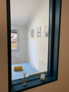 a mirror reflecting a room with a bed in it at Le cocon amiénois in Amiens