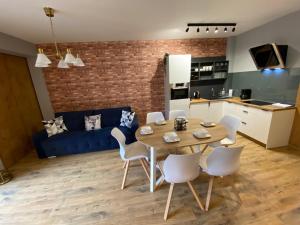 uma cozinha e sala de estar com uma mesa de madeira e cadeiras em Angelika 9A/3 Mountain Aparts em Świeradów-Zdrój