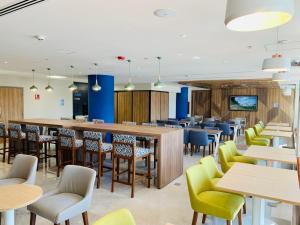 a restaurant with tables and chairs and a bar at Holiday Inn Express - Guadalajara Vallarta Poniente, an IHG Hotel in Guadalajara