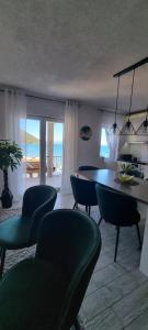 ein Wohnzimmer mit einem Tisch, Stühlen und Meerblick in der Unterkunft Private Villa by the sea in Žuljana