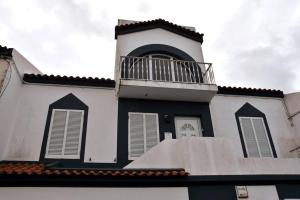 a black and white building with a balcony on it at Casa Da Torre in Ribeira Grande
