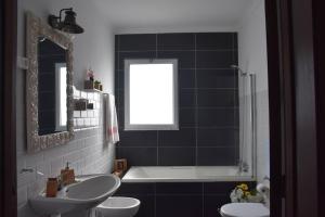 a bathroom with two sinks and a bath tub and a mirror at Casa Da Torre in Ribeira Grande