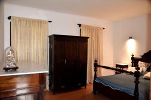 a bedroom with a bed and a wooden dresser at Casa Da Torre in Ribeira Grande