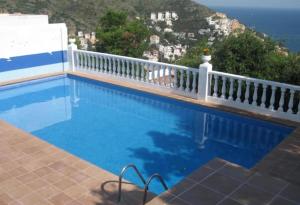 einen Pool mit einem weißen Zaun und dem Meer in der Unterkunft Casa con vistas al Mar Costa Bra in Roses