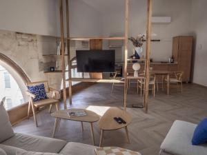 een woonkamer met een bank en een tafel met een tv bij LE NID BLEU Duplex en plein centre in Castres