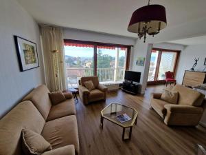 sala de estar con sofá, sillas y mesa en Au Beau Voyage à 2 pas des Thermes, en Thonon-les-Bains