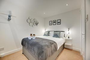 a white bedroom with a bed with two candles on it at Armstrong Apartments by Week2Week in Newcastle upon Tyne