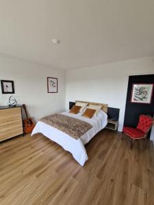 - une chambre avec un lit et une chaise rouge dans l'établissement Au Beau Voyage à 2 pas des Thermes, à Thonon-les-Bains
