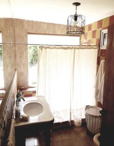 baño con lavabo y ventana en Cabaña Cultura Río en San Lorenzo