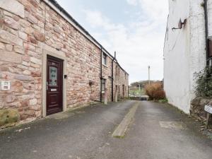 an empty alley with a brick building with a door at Tilly's Place in Heysham