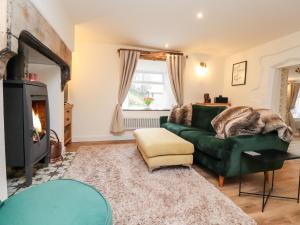 a living room with a green couch and a fireplace at Tilly's Place in Heysham