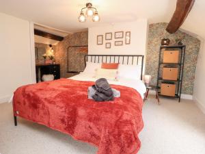 um quarto com uma cama grande e um cobertor vermelho em Tilly's Place em Heysham