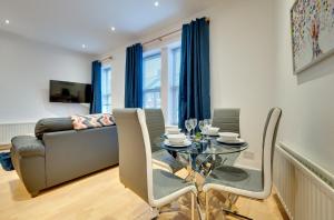 a living room with a table and a couch at Armstrong Apartments by Week2Week in Newcastle upon Tyne