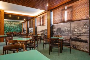 um restaurante com paredes e mesas e cadeiras de madeira em Hotel do Carmo no Funchal