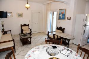 a living room with a table and chairs at Andros 2 berdrooms 4 persons cycladic house. in Kypri