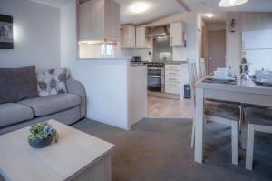 a living room and kitchen with a couch and a table at Ty Moselle 12 - 2 Bedroom Holiday Home - Amroth in Amroth