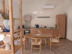 een keuken en eetkamer met een houten tafel en stoelen bij LE NID BLEU Duplex en plein centre in Castres