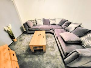 a living room with a couch and a coffee table at Large Modern House with Private Parking in Heeley