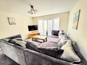 a living room with a couch and a tv at Large Modern House with Private Parking in Heeley