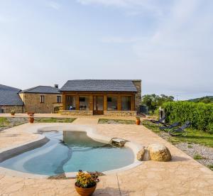 una piscina frente a una casa en O Viso Ecovillage - Hotel Ecologico Vegano, en Orol