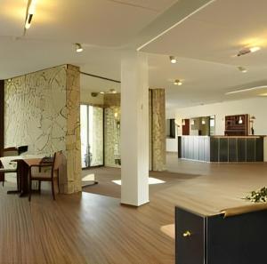 ein Wohnzimmer mit einem Tisch und einem Esszimmer in der Unterkunft Balland's Hotel & Restaurant in Lindwedel