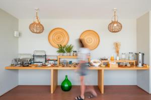 una mujer caminando por delante de un mostrador en una cocina en Blue Horizon, en Palaiochóra