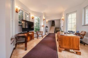 a living room with a kitchen and a dining room at Villa Tilia in Polanica-Zdrój