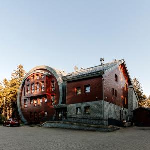 duży ceglany budynek z kopułowym dachem w obiekcie Hotel Obří Sud Javorník w mieście Jeřmanice