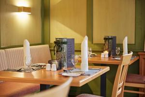 two tables in a restaurant with wine glasses on them at Haubers Naturresort Landhaus in Oberstaufen