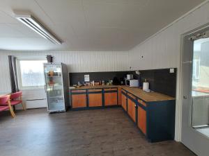 a kitchen with a refrigerator and a counter top at Soltun Soldatheim & Ungdomssenter in Sætermoen