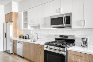 a white kitchen with a stove and a microwave at Silverlake 1br w wd roof nr 5 10 freeways LAX-978 in Los Angeles