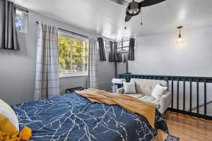 1 dormitorio con cama, sofá y ventana en Downtown Guest House en Raleigh