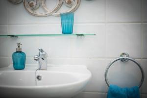 阿布里斯Riva Eco Guest House的浴室设有水槽和架子上的蓝色花瓶